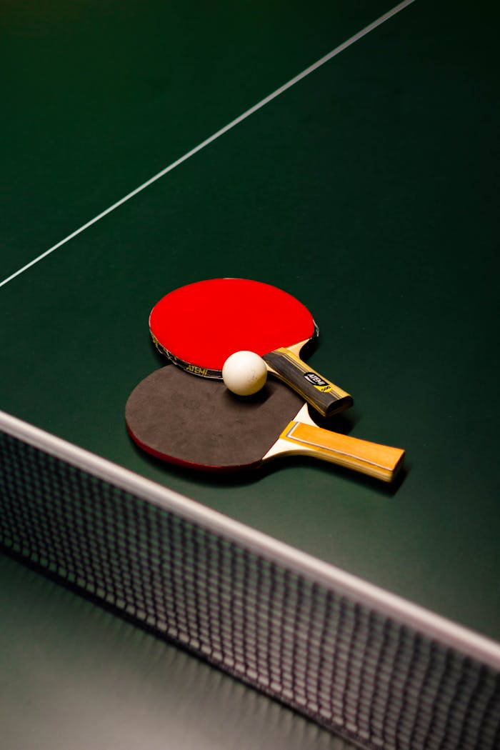 services-03 Table tennis paddles and ball on a green table. Ideal for sports themes.